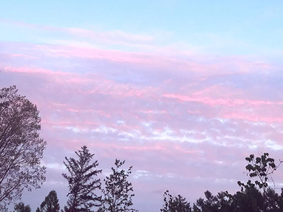 ピンク色の雲がたなびく幻想的な夕暮れ